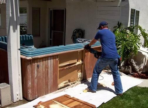 Professional hot tub removal crew dismantling an above ground spa